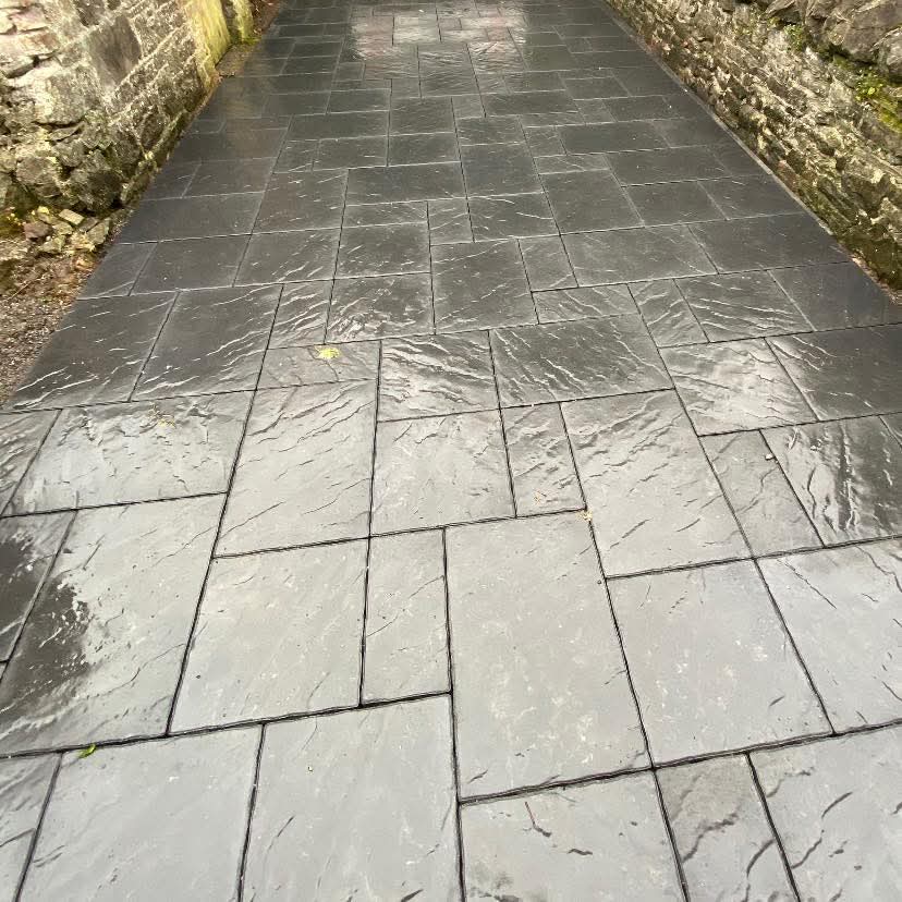Slate-effect paving pathway between stone walls